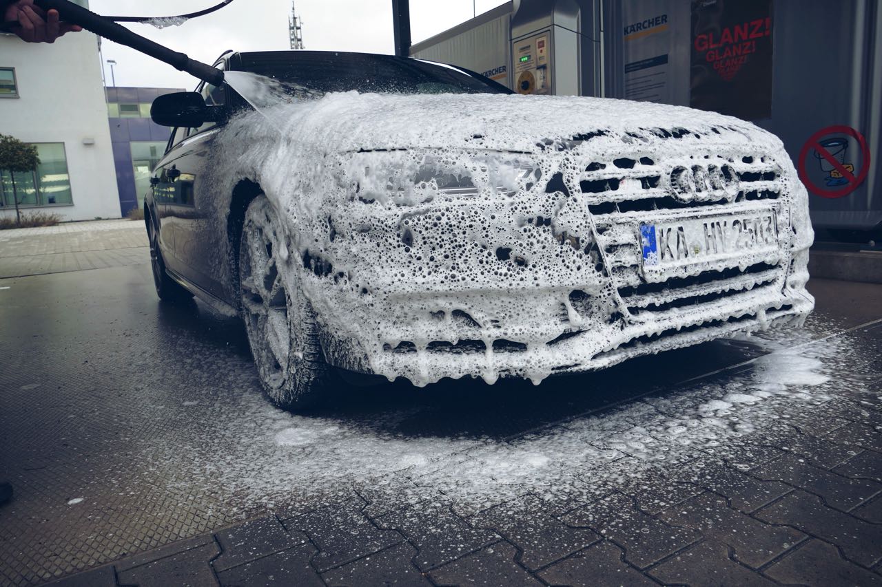 Ein Audi-Auto wird mit Schaum bedeckt, während es in einer Waschanlage gewaschen wird.